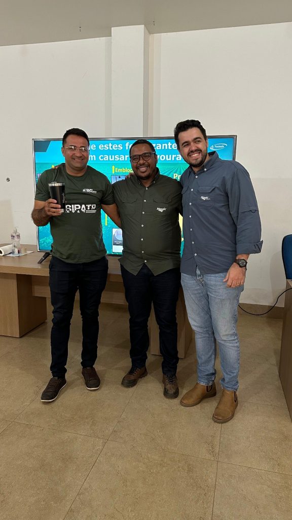 Três participantes da 4ª Semana Técnica do Grupo Hervalense em frente a uma apresentação sobre nutrição de safras, promovida pela Mosaic Fertilizantes.