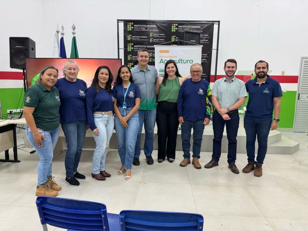 Participantes do evento em comemoração ao Dia Mundial da Agricultura no IFMT Campus Diamantino, incluindo representantes do Grupo Hervalense e da comunidade acadêmica, posam para foto em ambiente interno do auditório.